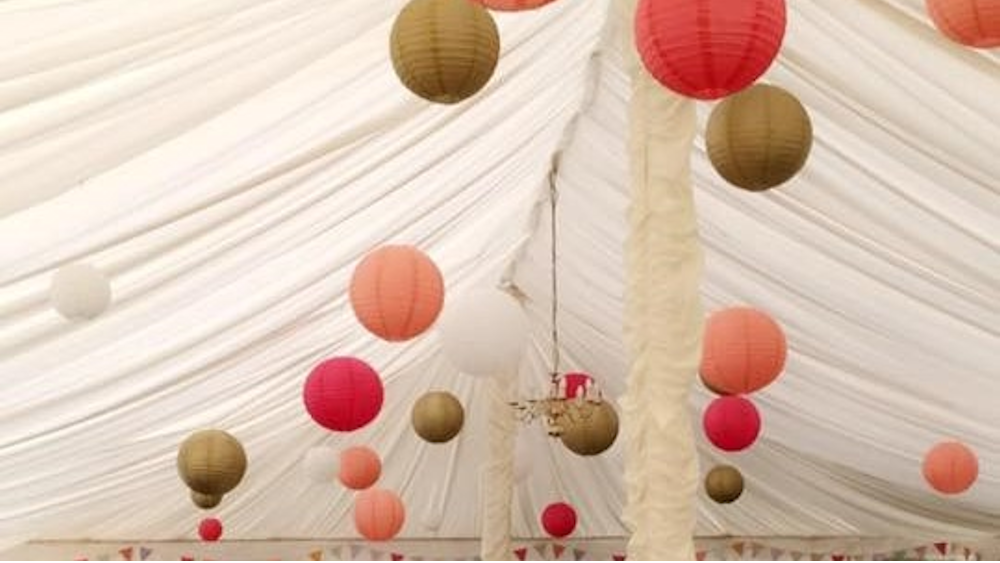 Coral and Gold Lanterns Brighten a Traditional Pole Tent