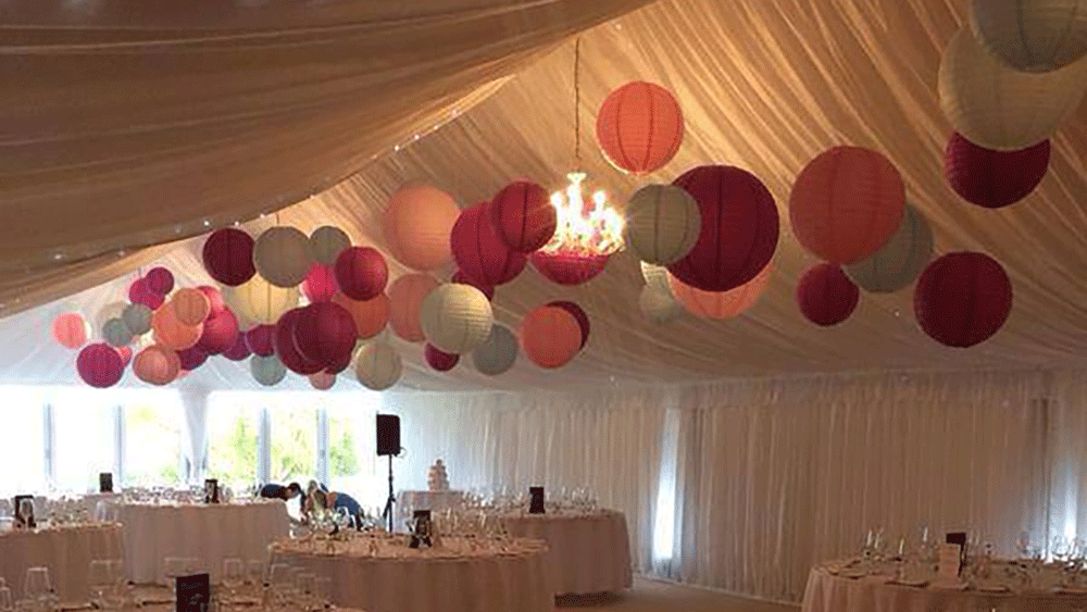 Pink and blue paper lanterns wow in this wedding marquee