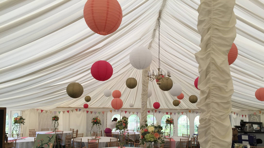 Coral and Gold Lanterns Brighten a Traditional Pole Tent